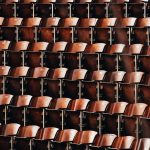 Rows of brown wooden seats in a lecture hall