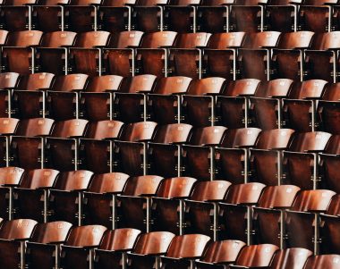 Rows of brown wooden seats in a lecture hall
